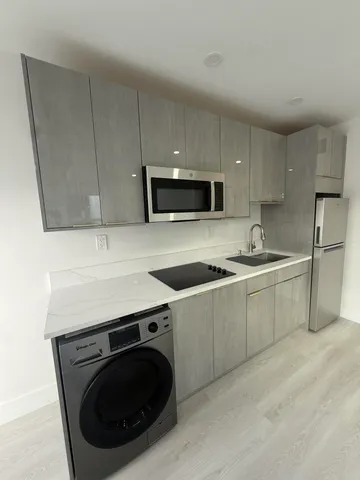 a kitchen with a sink a stove a microwave and cabinets