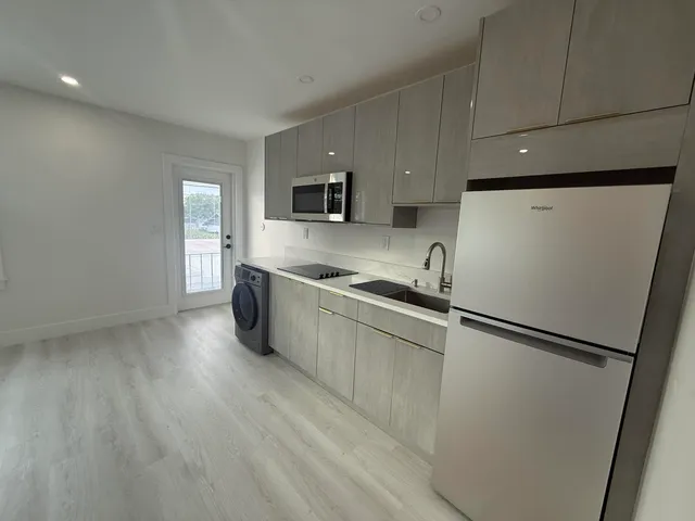 a kitchen with stainless steel appliances a refrigerator sink and microwave