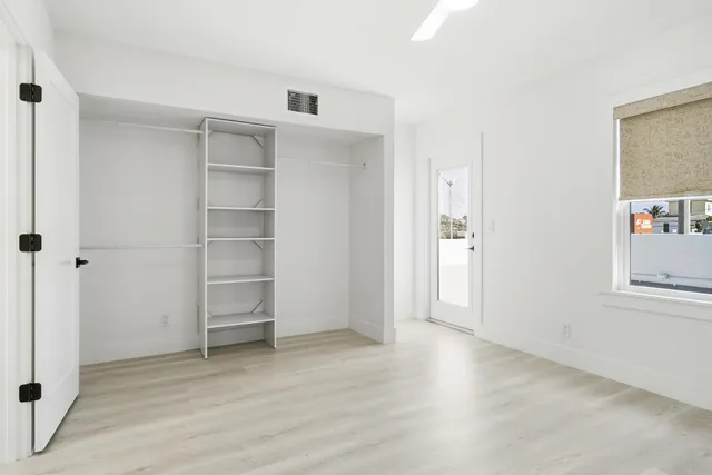 an empty room with cabinet and windows