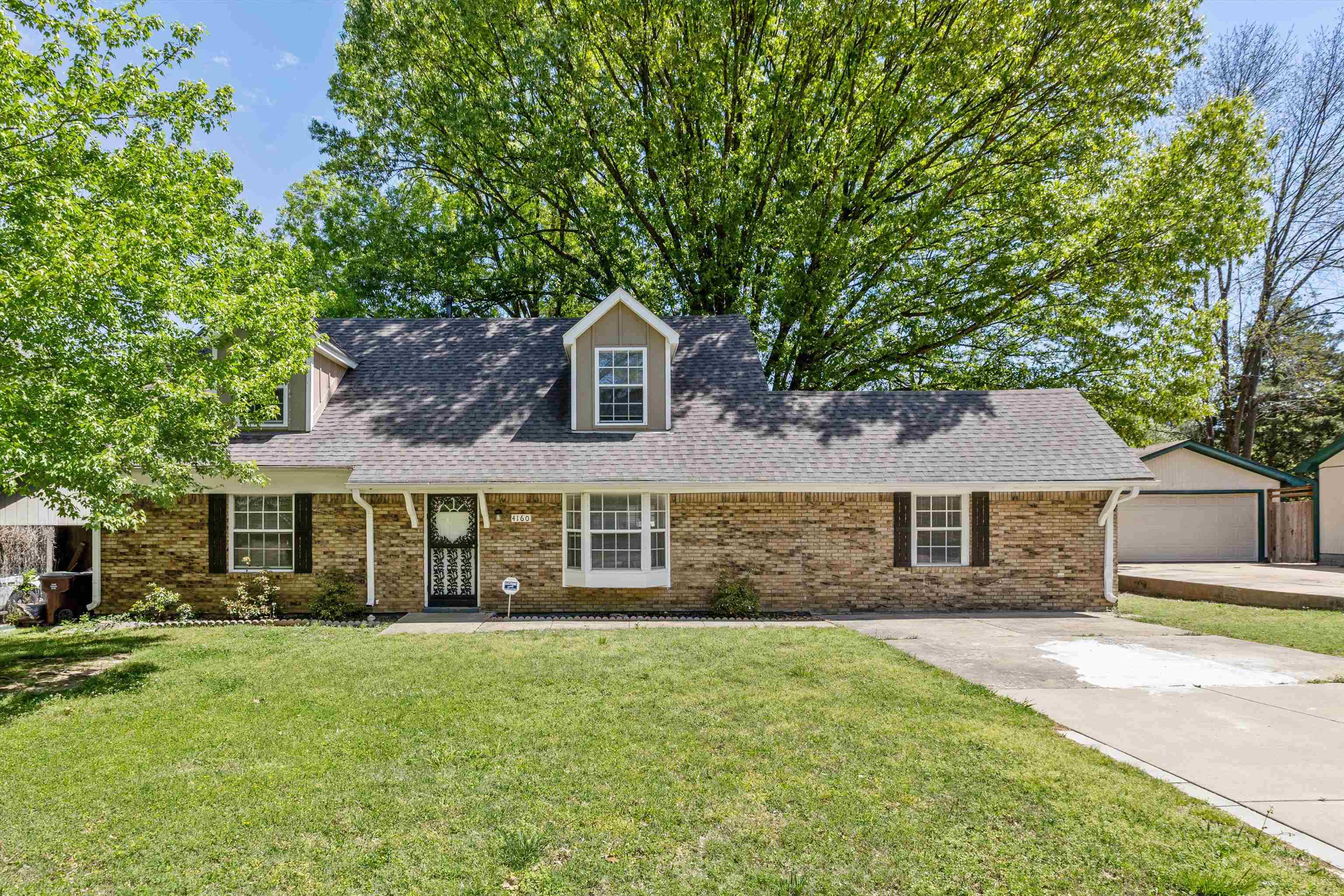 4160 Luther Road Bartlett, TN 38135 - Photo 1 of 28 Cape cod-style house with brick siding, an outbuilding, a shingled roof, and a front lawn