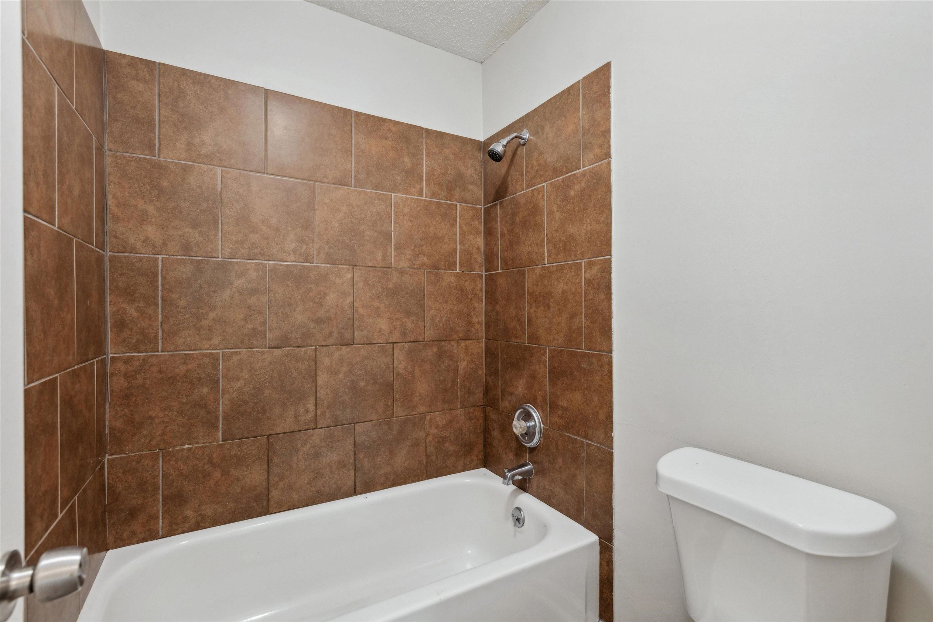4160 Luther Road Bartlett, TN 38135 - Photo 19 of 28 Full bathroom featuring washtub / shower combination, a textured ceiling, and toilet