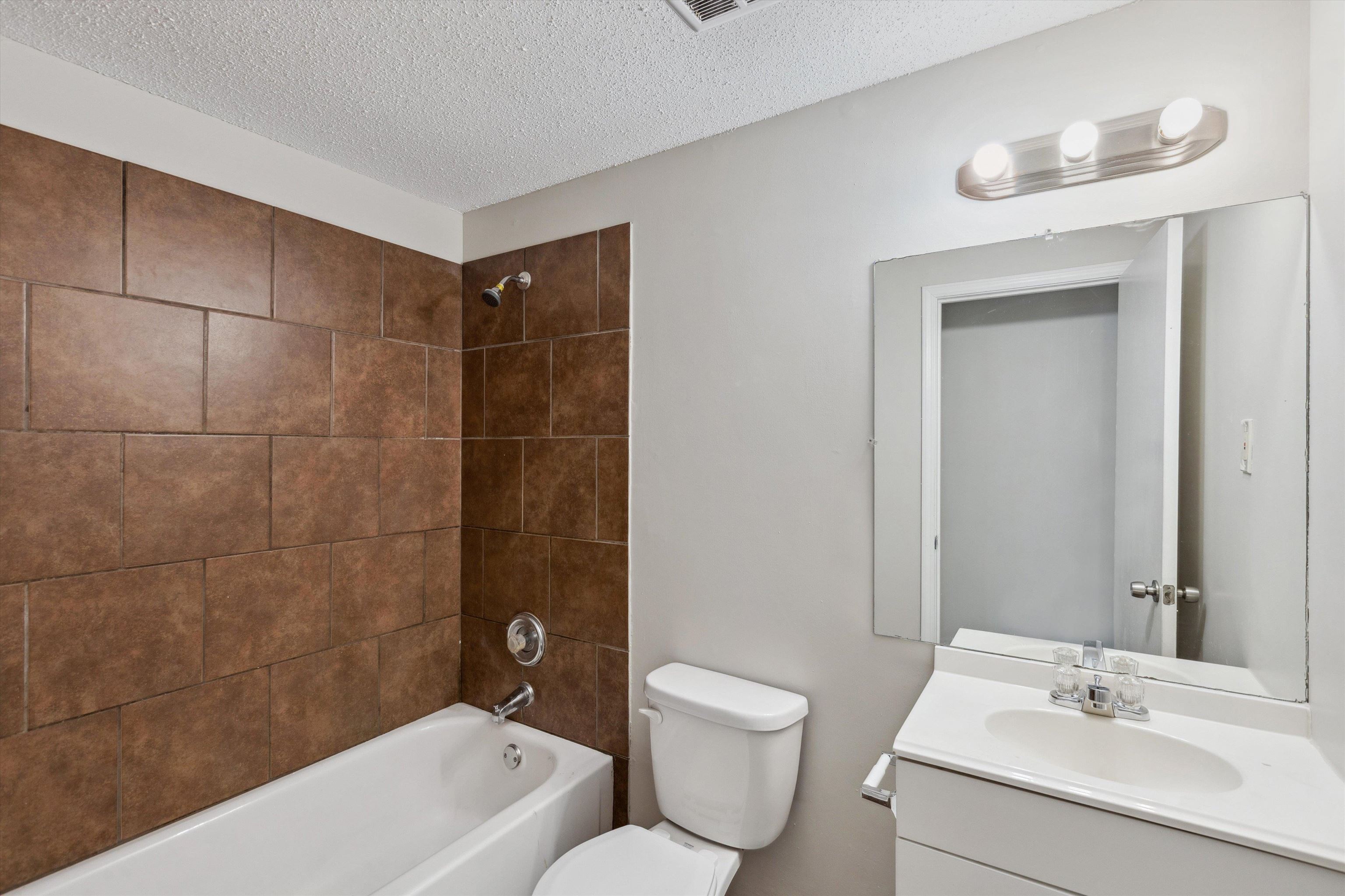 4160 Luther Road Bartlett, TN 38135 - Photo 23 of 28 Bathroom with a textured ceiling, toilet, vanity, and bathtub / shower combination