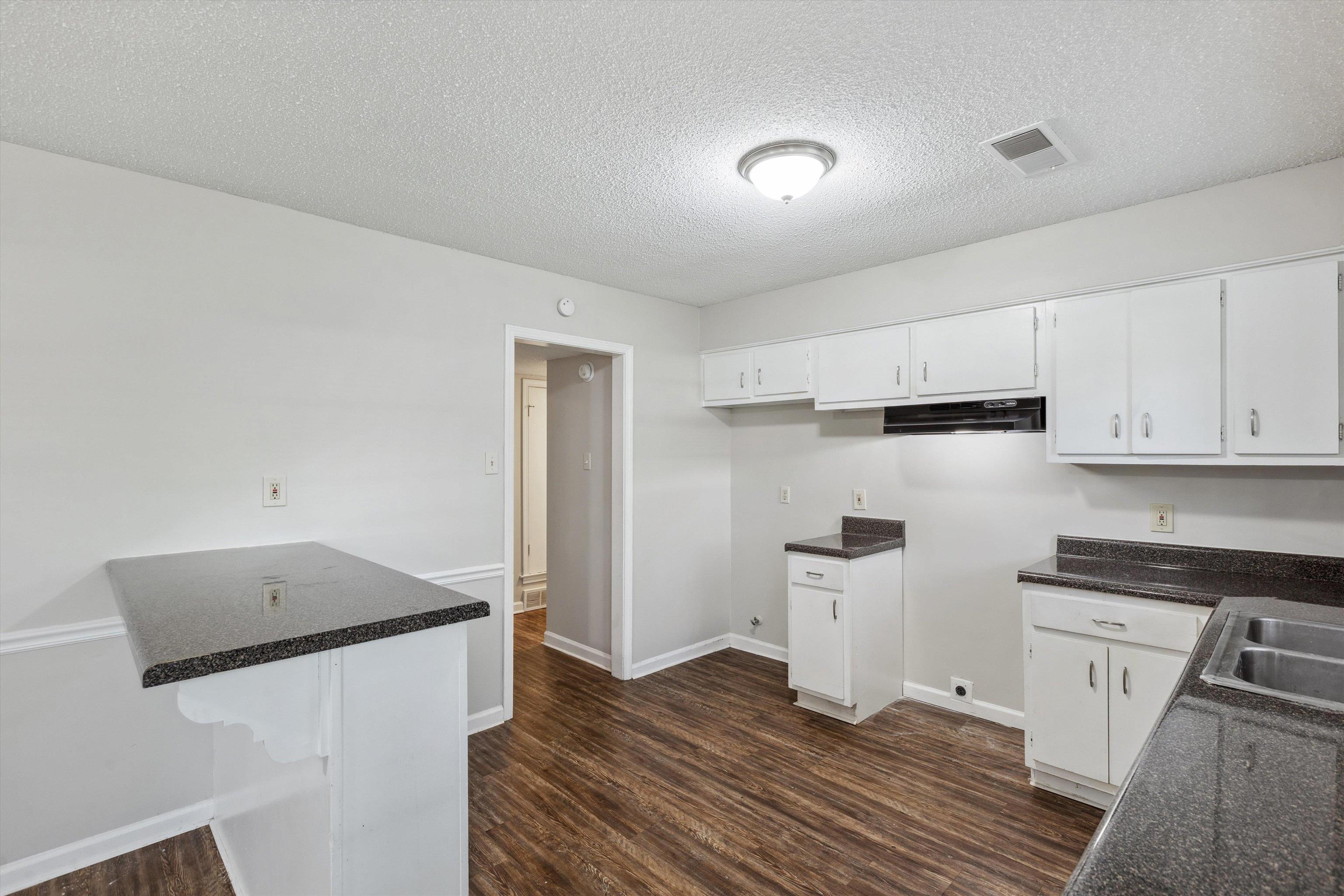4160 Luther Road Bartlett, TN 38135 - Photo 9 of 28 Kitchen with white cabinets, a textured ceiling, a sink, visible vents, and dark wood-type flooring
