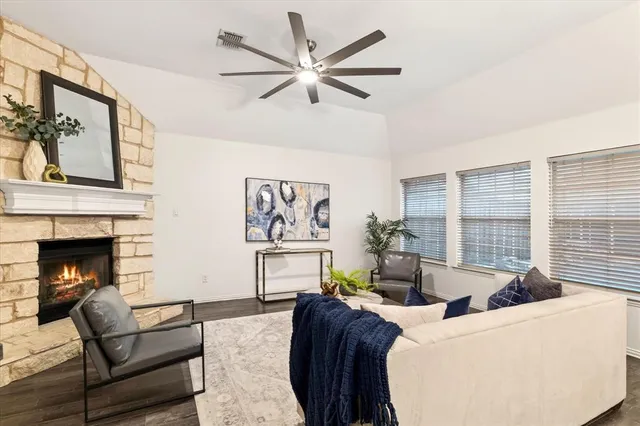 a living room with furniture a fireplace and a large window