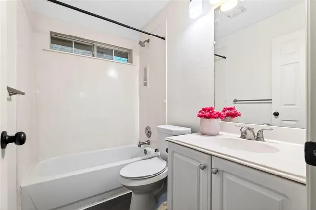 a bathroom with a sink vanity mirror and tub