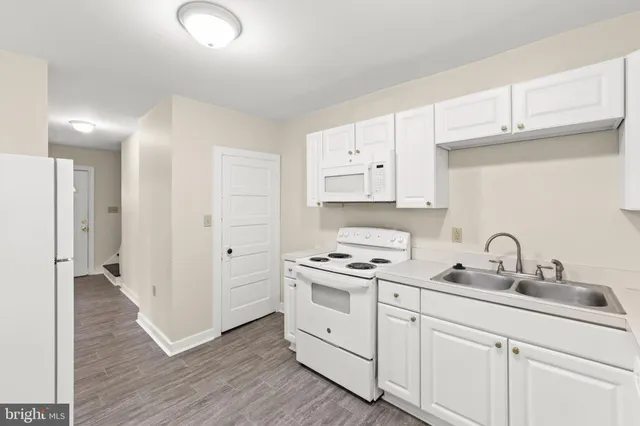a kitchen with white cabinets and white appliances