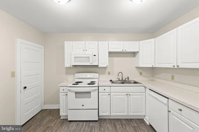 a kitchen with white cabinets and white appliances