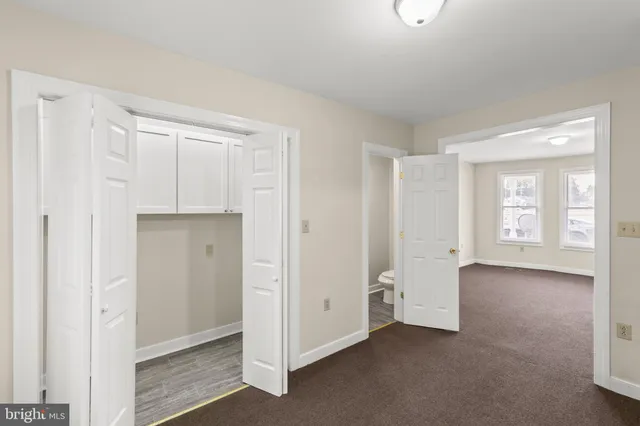 a view of an empty room with window and bathroom