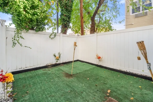 a backyard of a house with plants and large trees