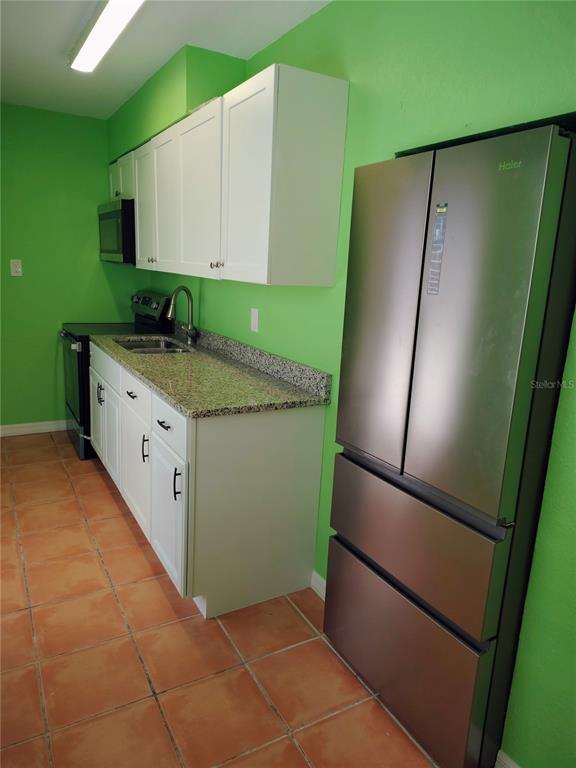 115 145th Avenue, Unit 4 Madeira Beach, FL 33708 - Photo 6 of 11 a kitchen with a refrigerator and a sink