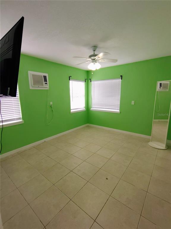 115 145th Avenue, Unit 4 Madeira Beach, FL 33708 - Photo 7 of 11 a view of an empty room with a window and a flat screen tv