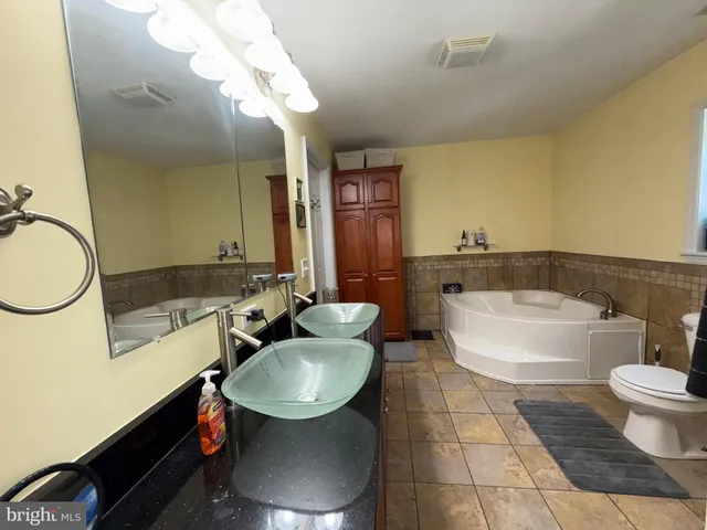 a bathroom with a sink a toilet and a mirror