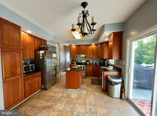 a kitchen with stainless steel appliances granite countertop a refrigerator a sink a stove and island