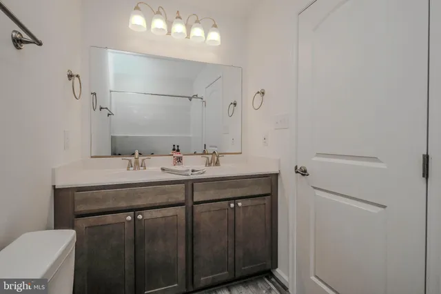 a bathroom with a tub sink vanity and toilet