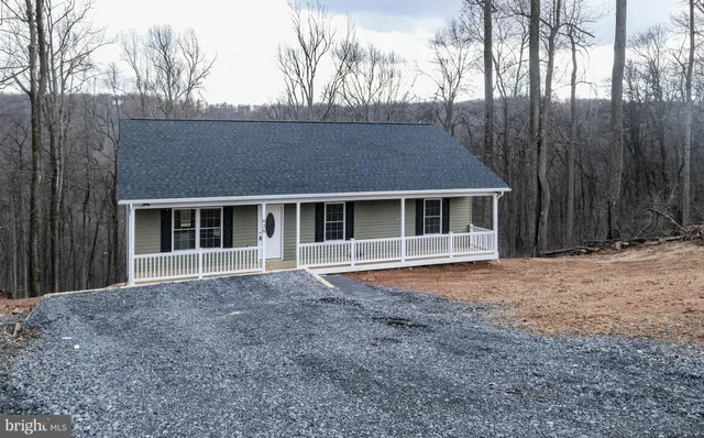 a front view of a house with a yard and potted plants