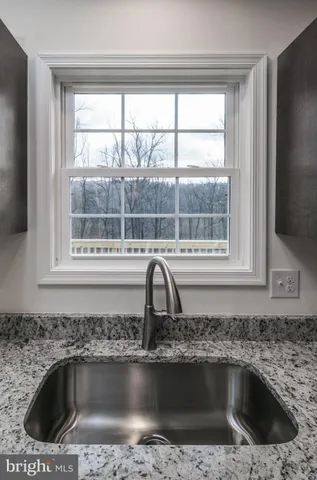 a large white kitchen with a large window and stainless steel appliances