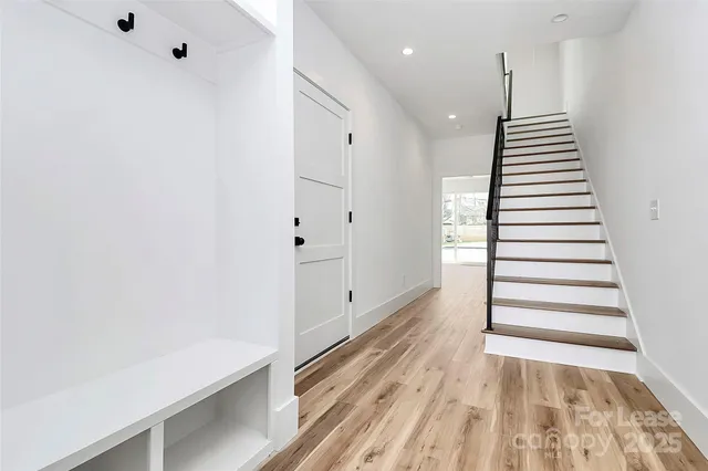 a view of a hallway with stairs and wooden floor