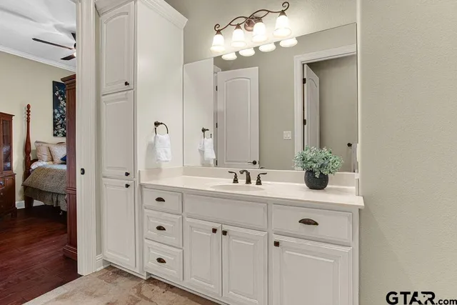 a bathroom with a granite countertop sink a mirror a vanity and a bathtub