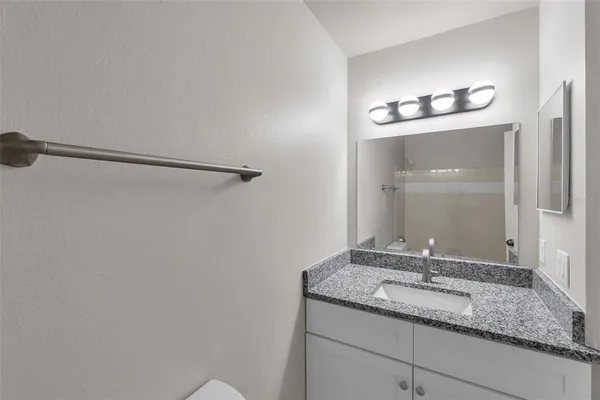 a bathroom with a granite countertop sink and a mirror