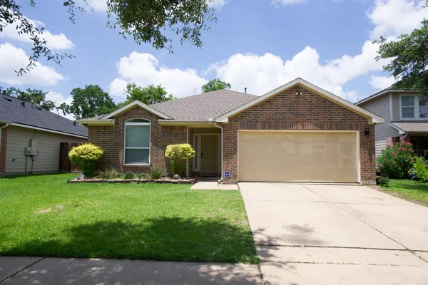 a front view of a house with a garden and yard