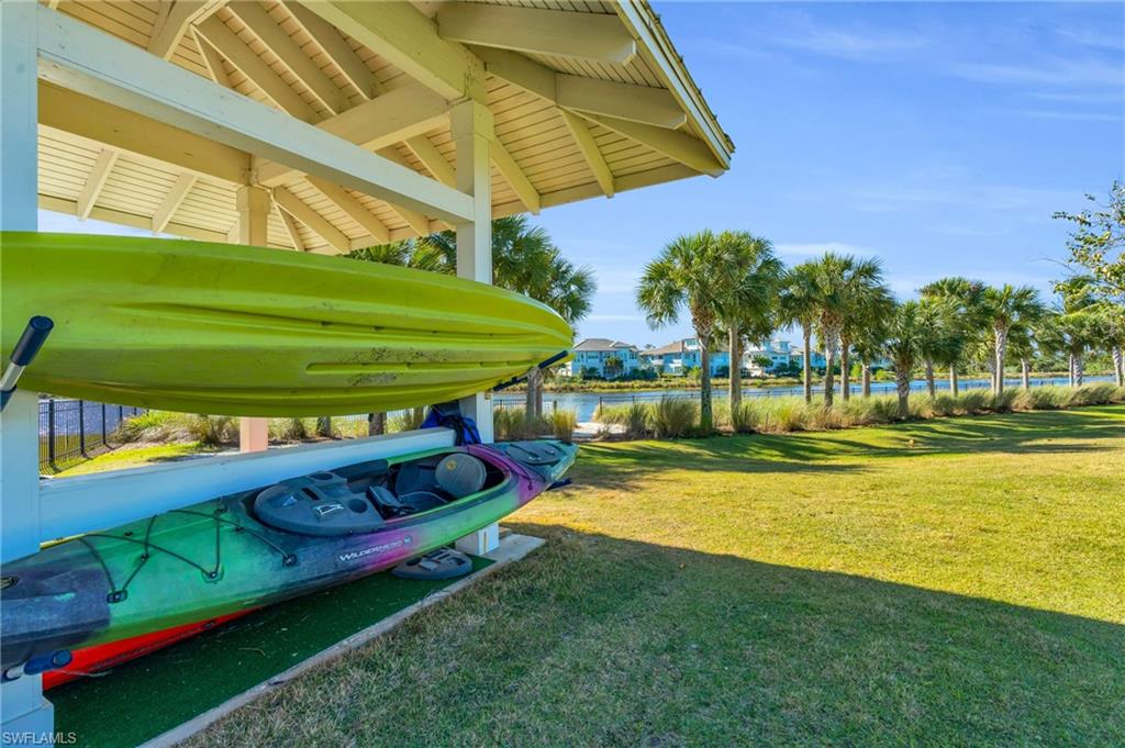 8937 Calypso Court Naples, FL 34113 - Photo 34 of 43 a view of a swimming pool with a bench and lawn chairs under an umbrella