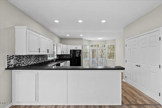 a kitchen with stainless steel appliances granite countertop a sink and a white cabinets