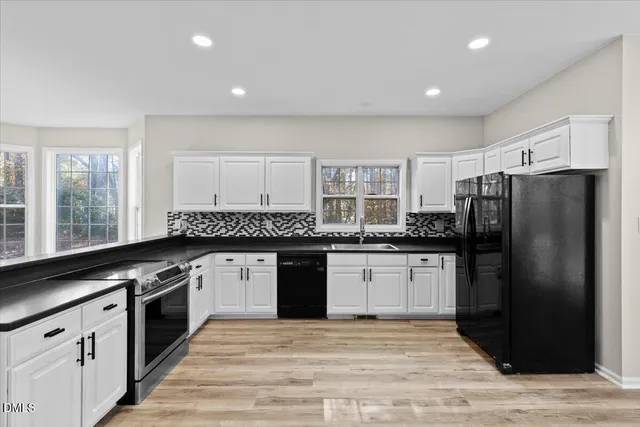 a kitchen with granite countertop a refrigerator stove top oven and sink