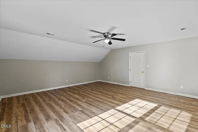 a view of a room with wooden floor and a chandelier fan