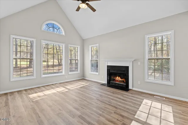 a view of an empty room with a window and fireplace