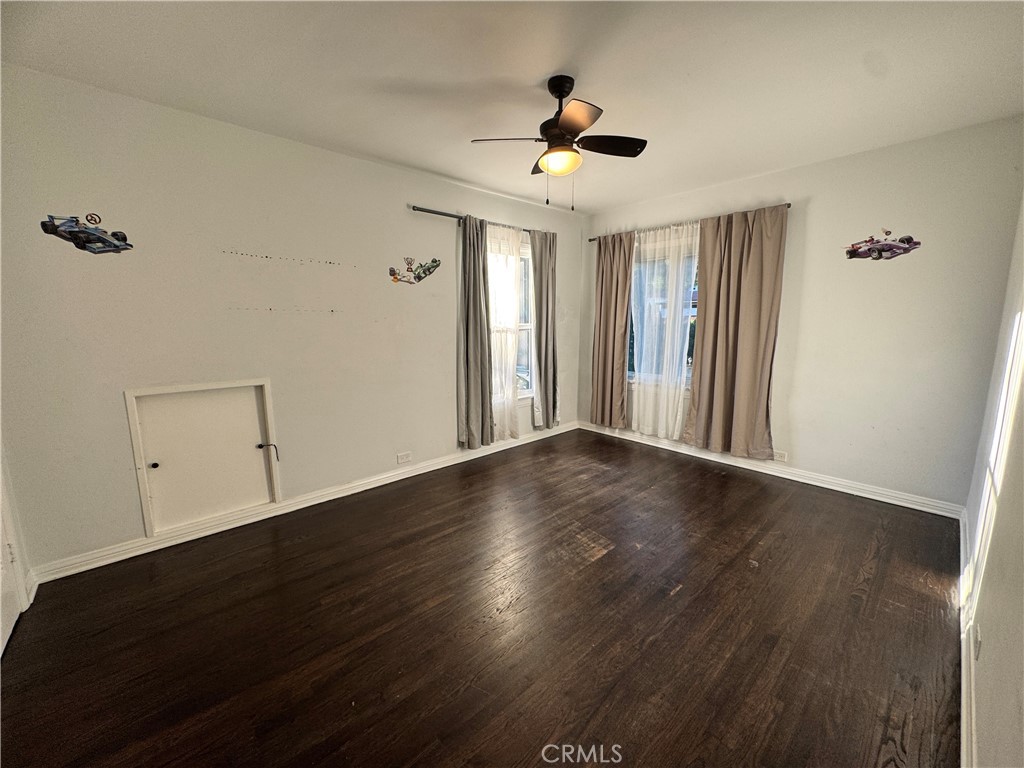 2248 East Chevy Chase Drive Glendale, CA 91206 - Photo 21 of 25 a view of an empty room with wooden floor and a ceiling fan