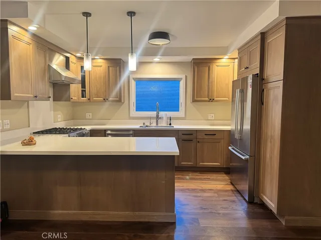 a kitchen with kitchen island granite countertop a sink appliances and cabinets