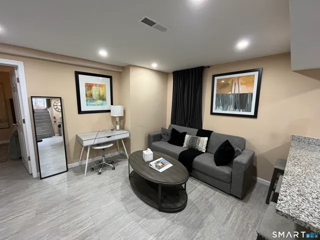 a living room with furniture and wooden floor