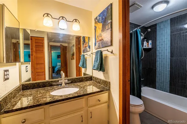 a bathroom with a granite countertop sink and a mirror
