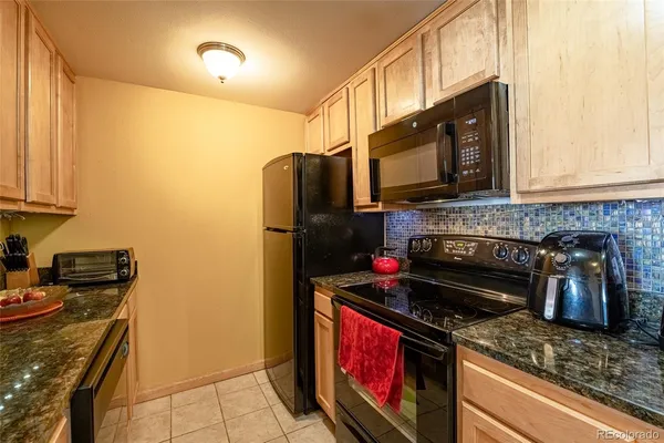 a kitchen with stainless steel appliances granite countertop a stove a refrigerator and a microwave