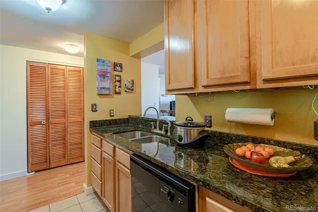 a kitchen with granite countertop a sink a stove and cabinets