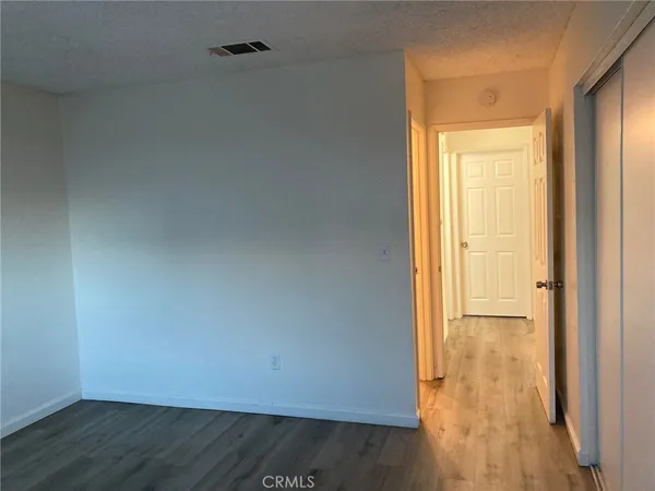 an empty room with wooden floor and door