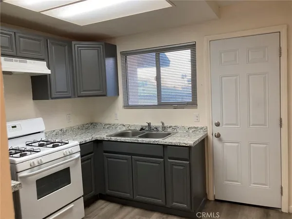 a kitchen with a sink stove and cabinets