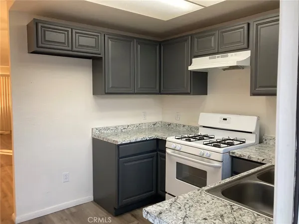 a kitchen with granite countertop a stove and a sink