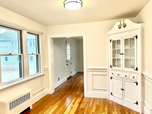 a view of a bedroom with wooden floor and windows