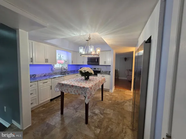 a kitchen with granite countertop kitchen island stainless steel appliances a sink stove and refrigerator