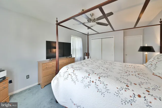 a spacious bedroom with a bed and a flat screen tv