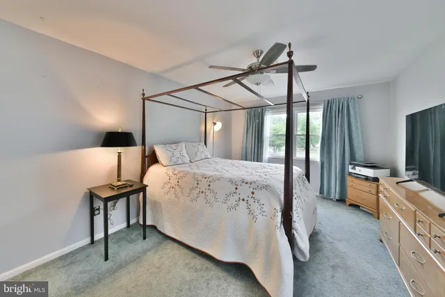 a bathroom with a granite countertop toilet a sink a mirror a window and a shower