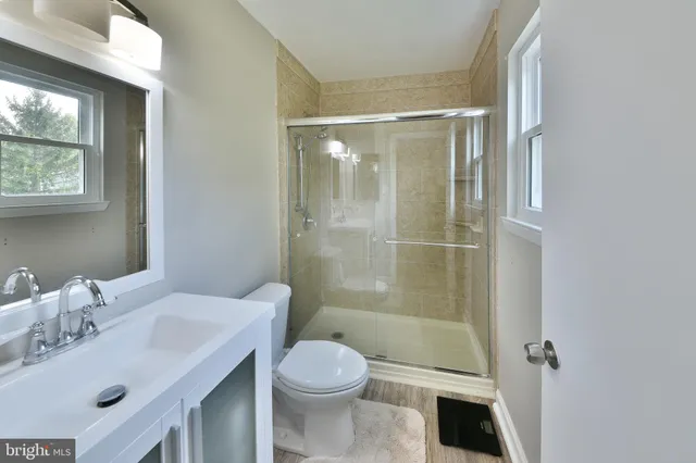 a bathroom with a sink mirror toilet and shower