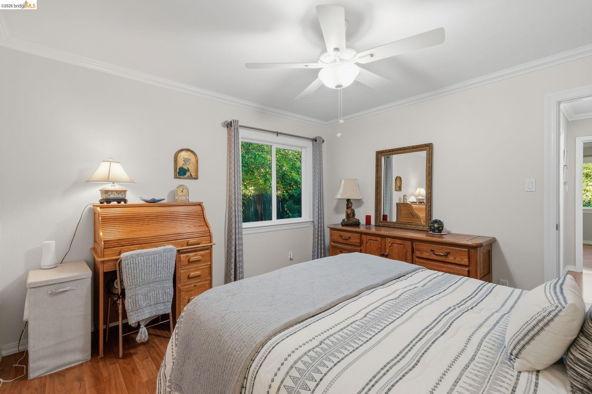5075 Alhambra Valley Road Martinez, CA 94553 - Photo 30 of 68 White painted walls with crown molding, wood-finish flooring, a ceiling fan with integrated lighting, and a single window offering natural light