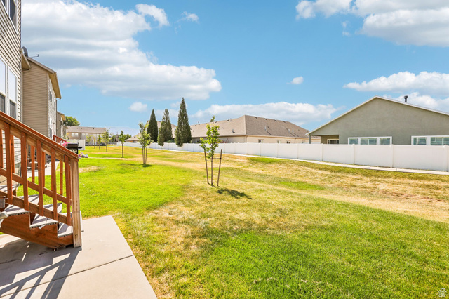 3215 West 450 North West Point, UT 84015 - Photo 27 of 40 Expansive backyard featuring a green lawn, established trees, and a durable white privacy fence