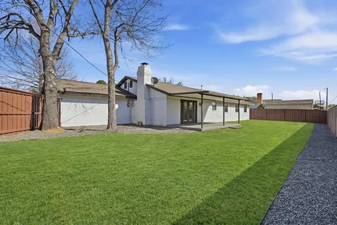 a view of a house with backyard and a tree