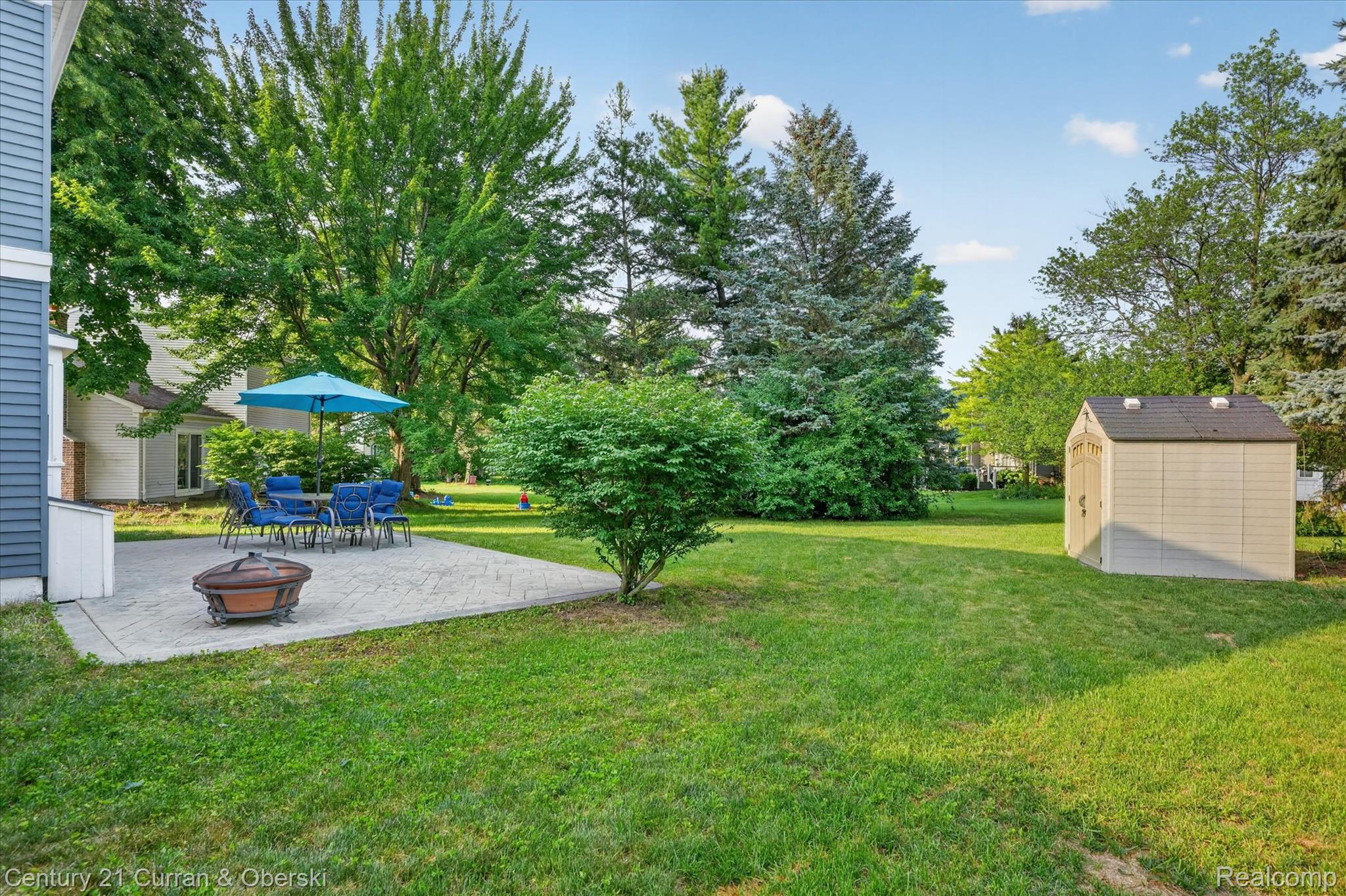24525 Jamestowne Road Novi, MI 48375 - Photo 34 of 34 Expansive backyard featuring a concrete paver patio, a freestanding storage shed, and mature trees