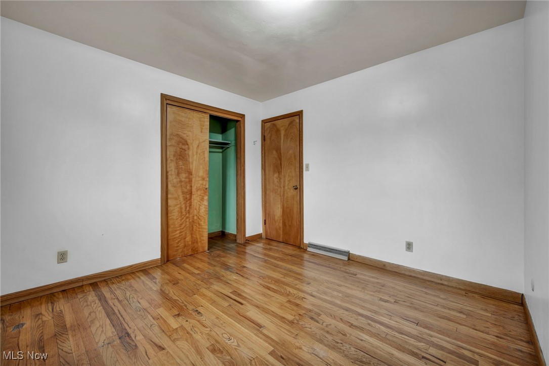 1140 Keefer Road Girard, OH 44420 - Photo 29 of 49 Unfurnished bedroom with light wood-type flooring, a closet, and baseboard heating