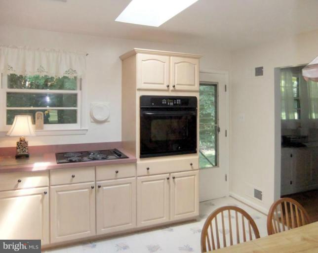 6411 Earlham Drive Bethesda, MD 20817 - Photo 2 of 16 a kitchen with stainless steel appliances granite countertop a stove a sink and a microwave
