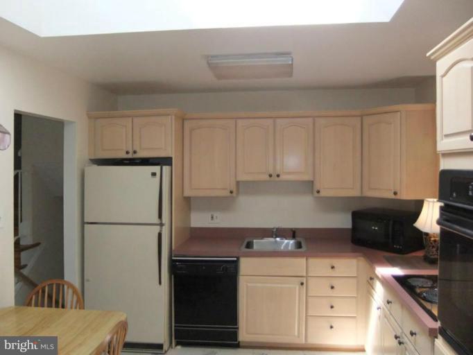 6411 Earlham Drive Bethesda, MD 20817 - Photo 4 of 16 a kitchen with refrigerator a stove and cabinets